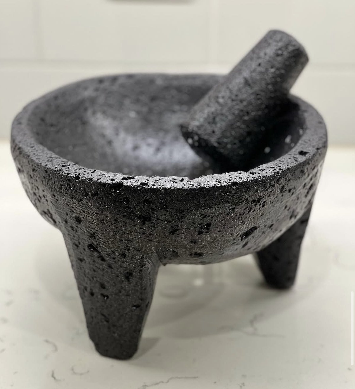 An empty volcanic-stone molcajete and pestle